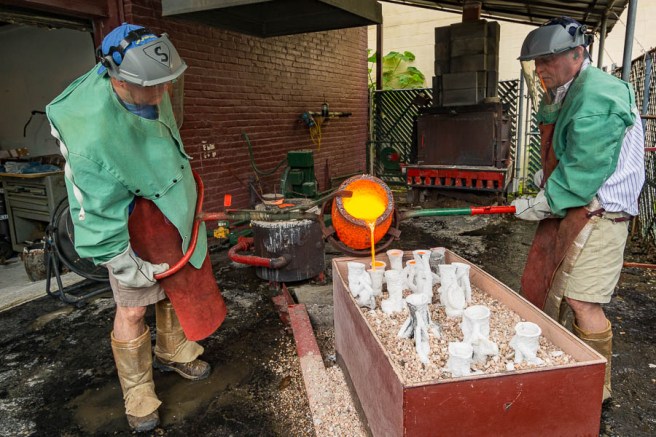 Steven and Stewart Wegner pouring molten bronze into molds.